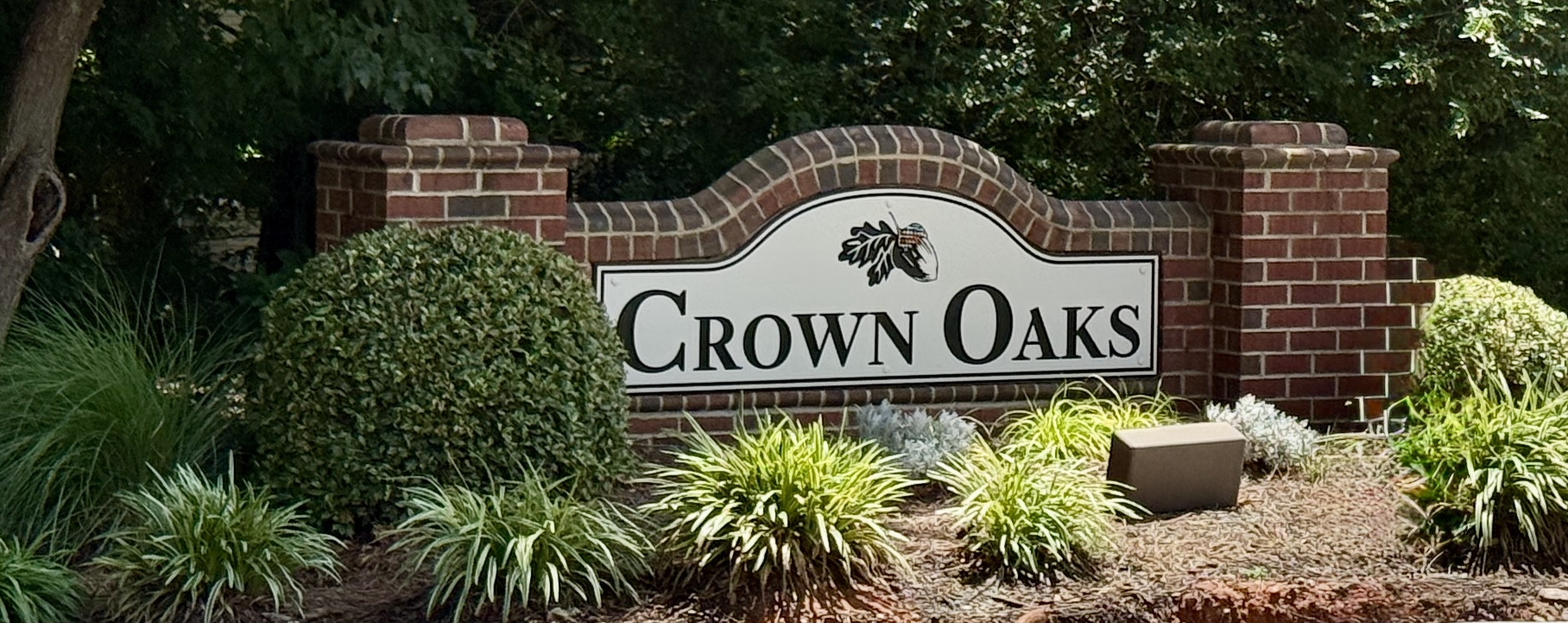 Wooded grounds and townhome buildings at Crown Oaks